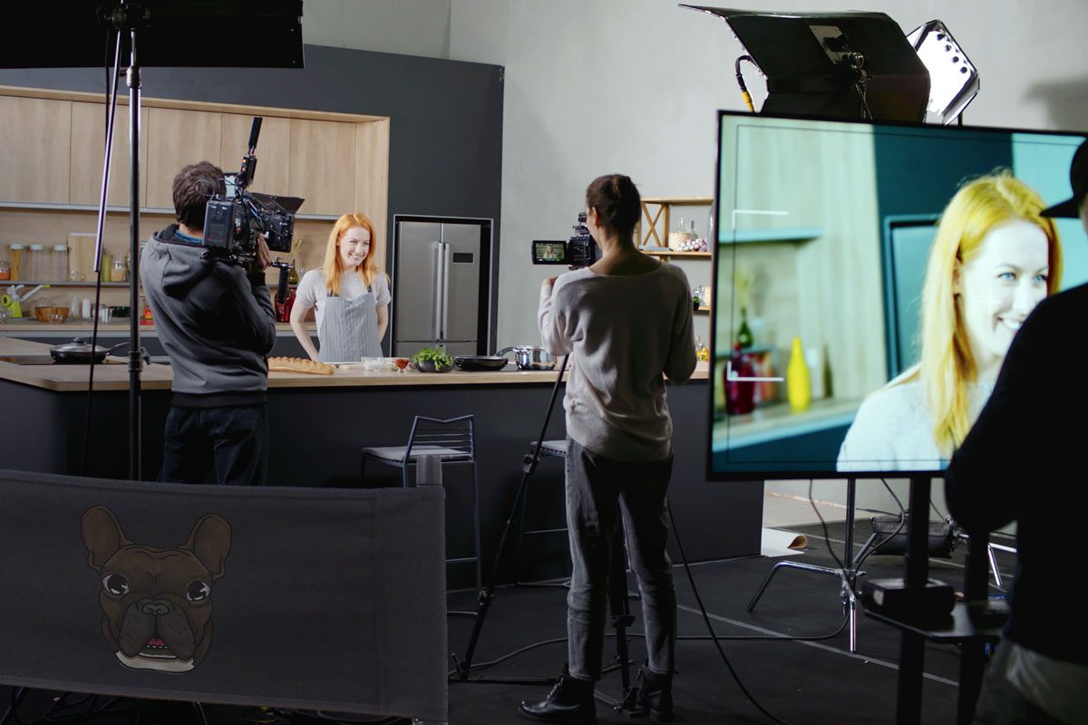 A look behind the scenes of a multi-camera shoot, featuring the Frenchbulldog Logo on a director chair/